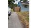 Home exterior featuring a driveway, partial view of the home, and a wooden fence in a partially grassy yard at 1408 San Juan Ct, Clearwater, FL 33756