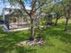 Expansive backyard featuring a screened-in lanai and lush green lawn at 14319 Morristown Ave, Port Charlotte, FL 33981