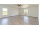 Spacious bedroom with hardwood floors, two windows, and a ceiling fan at 14319 Morristown Ave, Port Charlotte, FL 33981
