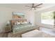 Modern bedroom with decor, ceiling fan, bed, and a large window at 14319 Morristown Ave, Port Charlotte, FL 33981
