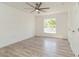 Bedroom featuring hardwood floors, white walls, large window, and a ceiling fan at 14319 Morristown Ave, Port Charlotte, FL 33981
