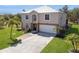 Two-story home with a large driveway, attached garage, and lush landscaping at 14319 Morristown Ave, Port Charlotte, FL 33981