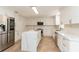 Bright kitchen features white cabinets, stainless steel appliances, and spacious island with quartz countertops at 14319 Morristown Ave, Port Charlotte, FL 33981
