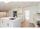 Bright kitchen boasts stainless steel appliances, white cabinetry and a center island with waterfall countertops at 14319 Morristown Ave, Port Charlotte, FL 33981
