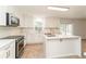 Modern kitchen features an island, stainless appliances, white cabinets, and sliding glass doors at 14319 Morristown Ave, Port Charlotte, FL 33981