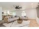 Bright living room with comfortable seating, ceiling fan, and a view of a pool table in the background at 14319 Morristown Ave, Port Charlotte, FL 33981
