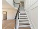 Modern staircase features dark wood treads, white risers, and sleek black metal railings at 14319 Morristown Ave, Port Charlotte, FL 33981