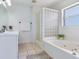 Bright bathroom features a glass block shower, soaking tub, and crisp white vanity at 14655 Joe Sumner Rd, Wimauma, FL 33598
