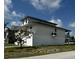 Exterior angle view of the waterfront home with white facade and two-car garage at 15621 Bertram Dr, Hudson, FL 34667