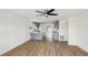 Open-concept living space with sleek ceiling fan, flowing into a modern kitchen with stylish blue cabinetry and wood flooring at 15621 Bertram Dr, Hudson, FL 34667