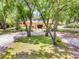 Charming home with mature trees, a landscaped yard, and a welcoming front entrance at 18826 Huckavalle Rd, Odessa, FL 33556
