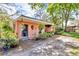 Garage exterior featuring a covered area, plants, and a gravel driveway at 18826 Huckavalle Rd, Odessa, FL 33556