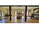 Elegant living room with dark wooden beams, travertine floors, and large windows, filled with art at 18826 Huckavalle Rd, Odessa, FL 33556