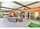 Large, covered outdoor living space with kitchen, dining area, and comfortable seating at 18826 Huckavalle Rd, Odessa, FL 33556