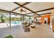 Spacious outdoor living room with a view of the pool and a covered kitchen and dining area at 18826 Huckavalle Rd, Odessa, FL 33556