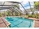Screened-in pool featuring a jacuzzi and in-pool lounge chair, perfect for relaxation at 18826 Huckavalle Rd, Odessa, FL 33556