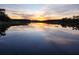 Scenic sunset reflecting on the tranquil lake, enhancing the property's serene appeal at 18826 Huckavalle Rd, Odessa, FL 33556