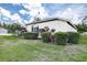 Exterior view of a home with well-manicured bushes, landscaping, and a green lawn at 1920 Folkstone Pl, Wesley Chapel, FL 33543