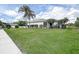Lush backyard featuring well-maintained green lawn, palm trees and a screened patio, perfect for outdoor relaxation at 1920 Folkstone Pl, Wesley Chapel, FL 33543
