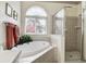 Bright bathroom featuring a soaking tub, walk-in shower, and view of outside at 1920 Folkstone Pl, Wesley Chapel, FL 33543