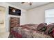 Comfortable bedroom setup with large TV, wooden dresser and matching decorative pillows at 1920 Folkstone Pl, Wesley Chapel, FL 33543