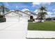 Beautiful home featuring mature palm trees, manicured landscaping, and a spacious driveway at 1920 Folkstone Pl, Wesley Chapel, FL 33543