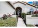 Inviting front entrance with a charming archway, well-maintained landscaping, and decorative exterior lighting at 1920 Folkstone Pl, Wesley Chapel, FL 33543