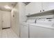 Laundry room featuring tile floors, washer, dryer, and cabinets at 1920 Folkstone Pl, Wesley Chapel, FL 33543