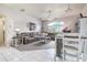 Open-concept living room features a cozy seating area, a ceiling fan, and a breakfast bar with barstool seating at 1920 Folkstone Pl, Wesley Chapel, FL 33543