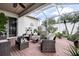 Relaxing screened patio with brick flooring, cozy seating, and lush plants, offering a private outdoor retreat at 1920 Folkstone Pl, Wesley Chapel, FL 33543