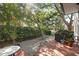 Backyard patio with brick pavers, decorative stone, lush plants, and a covered grill at 2314 S Clewis Ct # 106, Tampa, FL 33629