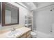 Well-lit bathroom featuring neutral vanity sink, framed mirror, bathtub, shower, and white shelving at 2314 S Clewis Ct # 106, Tampa, FL 33629