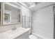 Well-maintained bathroom featuring vanity sink, framed mirror, bathtub, shower, and glass shelving at 2314 S Clewis Ct # 106, Tampa, FL 33629
