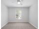 Empty bedroom featuring neutral carpet, a ceiling fan, and a bright window at 2314 S Clewis Ct # 106, Tampa, FL 33629