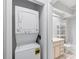 Stacked washer and dryer next to the bathroom with vanity sink, bathtub, shower, and white shelving at 2314 S Clewis Ct # 106, Tampa, FL 33629
