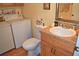 Cozy bathroom featuring a washing machine, a toilet, and vanity with wood cabinets at 2725 14Th Ct, Palm Harbor, FL 34684