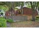 A brick house with a red tile roof and a fence in front surrounded by palm trees at 2725 14Th Ct, Palm Harbor, FL 34684