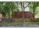 A brick home with a red tile roof and mature trees in front of the building at 2725 14Th Ct, Palm Harbor, FL 34684