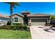 Charming single-story home featuring a tile roof, manicured landscaping, and a brick paver driveway at 2855 Oriole Dr, Sarasota, FL 34243