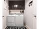 Well-organized laundry room with washer, dryer, cabinets, shelving and dark accent wall at 2855 Oriole Dr, Sarasota, FL 34243