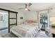 Relaxing bedroom featuring a sliding barn door to bathroom, ceiling fan and a window at 3131 W Fielder St, Tampa, FL 33611
