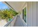 Long, covered balcony with views of lush tropical greenery and blue skies at 3901 Pompano Se Dr, St Petersburg, FL 33705