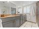 Bathroom with double sinks, white tile flooring, neutral cabinets and a shower at 3901 Pompano Se Dr, St Petersburg, FL 33705