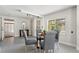 Neutral dining room with modern lighting, a glass table, and gray upholstered chairs at 3901 Pompano Se Dr, St Petersburg, FL 33705