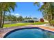 A gorgeous in-ground pool in a manicured tropical backyard with a waterway beyond at 3901 Pompano Se Dr, St Petersburg, FL 33705
