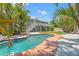 Backyard pool surrounded by tropical greenery and a charming two-story home at 3901 Pompano Se Dr, St Petersburg, FL 33705