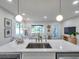 Open kitchen overlooking the living room featuring pendant lighting, modern appliances, and a breakfast bar at 400 38Th Ne Ave, St Petersburg, FL 33703