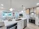 Open kitchen with stainless steel appliances, a white quartz countertop island, and a view of the living room at 400 38Th Ne Ave, St Petersburg, FL 33703