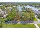 Aerial view of a lakeside home surrounded by lush greenery in a quiet residential neighborhood at 4121 Highland Park Cir, Lutz, FL 33558