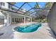 Spacious backyard with a pool, covered patio, outdoor kitchen, and lovely lake views at 4121 Highland Park Cir, Lutz, FL 33558